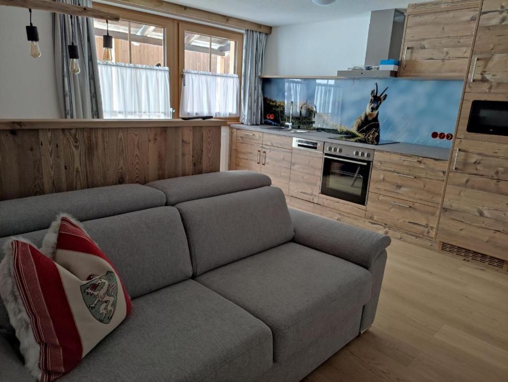 a living room with a couch and a kitchen at Bauernhof - Appartement beim Zefferer in Schladming