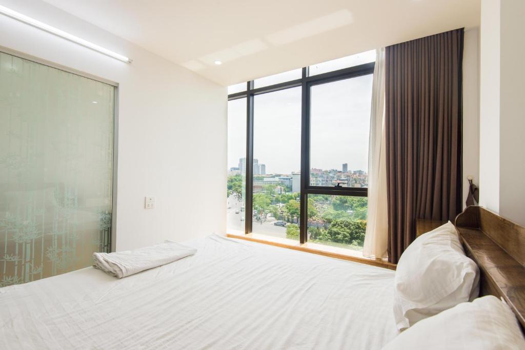 a bedroom with a bed and a large window at 22housing Cau Giay Hotel & Residence in Hanoi