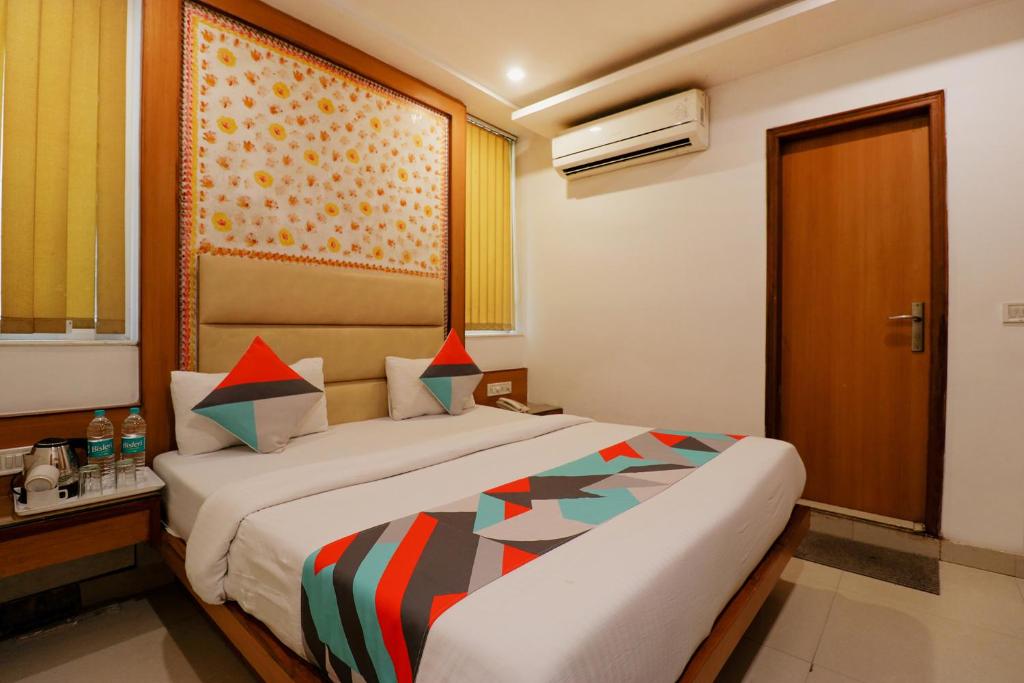a hotel room with a bed and a window at FabHotel Baba Residency in New Delhi