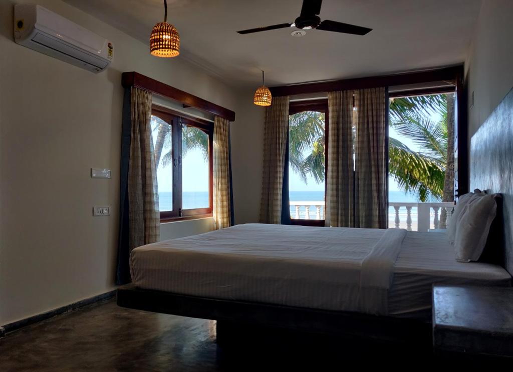 a bedroom with a bed with a view of the ocean at Silent Beach Resort in Mandrem