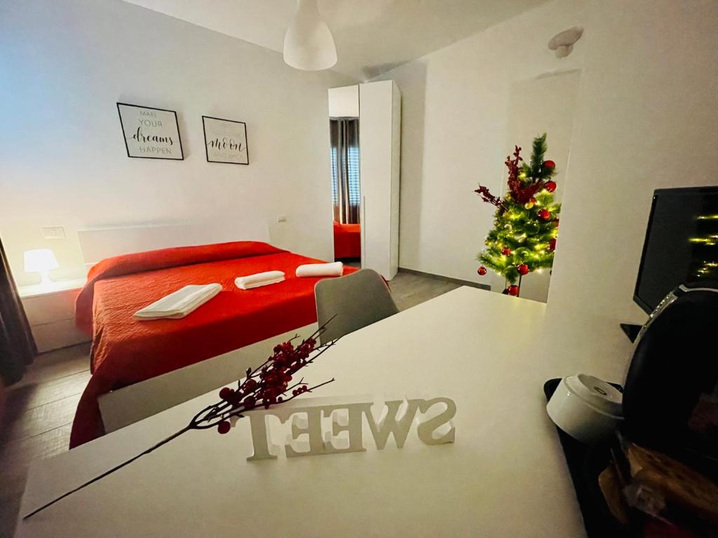 um quarto de hotel com uma cama e uma árvore de Natal em La cittadella rooms em Monserrato
