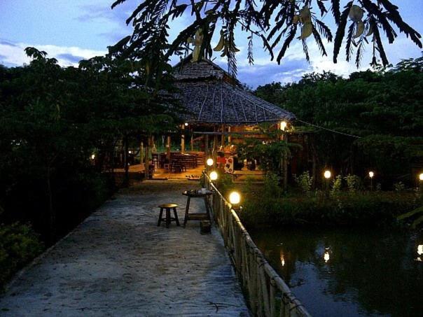 a night view of a building with a table and lights at Paipunthong Resort in Pai