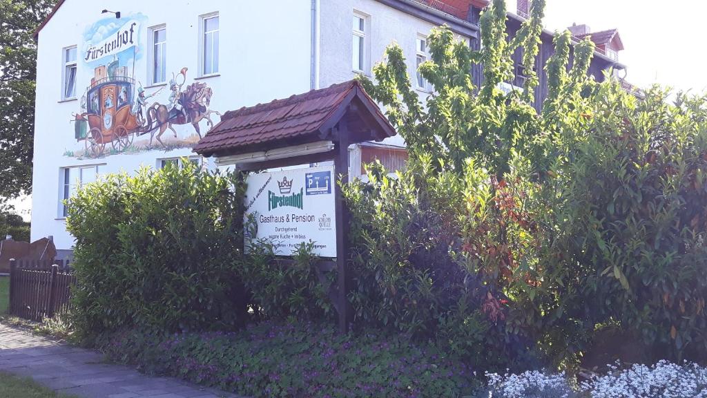 une maison blanche avec un panneau devant elle dans l'établissement Fürstenhof Landgasthaus & Hotel, à Erfurt