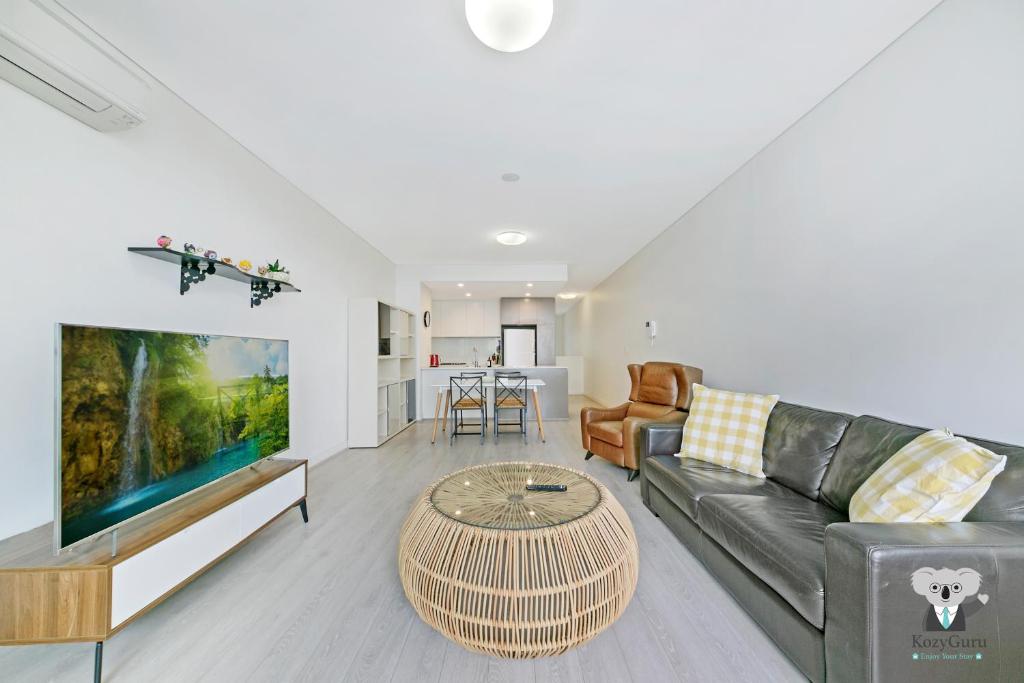 sala de estar con sofá y TV en KOZYGURU MASCOT 2 BED APT FREE DOUBLE-PARKING NMA629 en Sídney