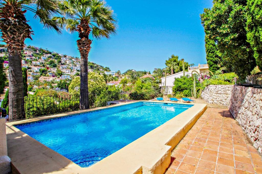 ベニッサにあるMonica - holiday home with private swimming pool in Benissaのヤシの木が茂るヴィラ内のスイミングプール