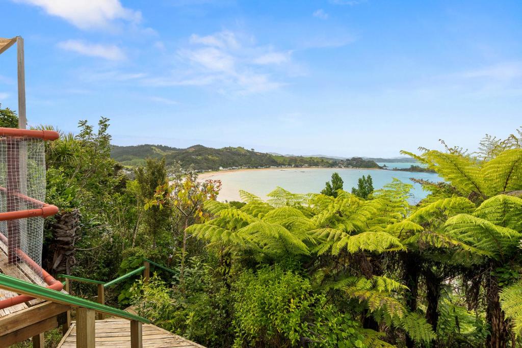 a view of a beach with palm trees at Bach and Relax - Oakura Holiday Home in Whangaruru North