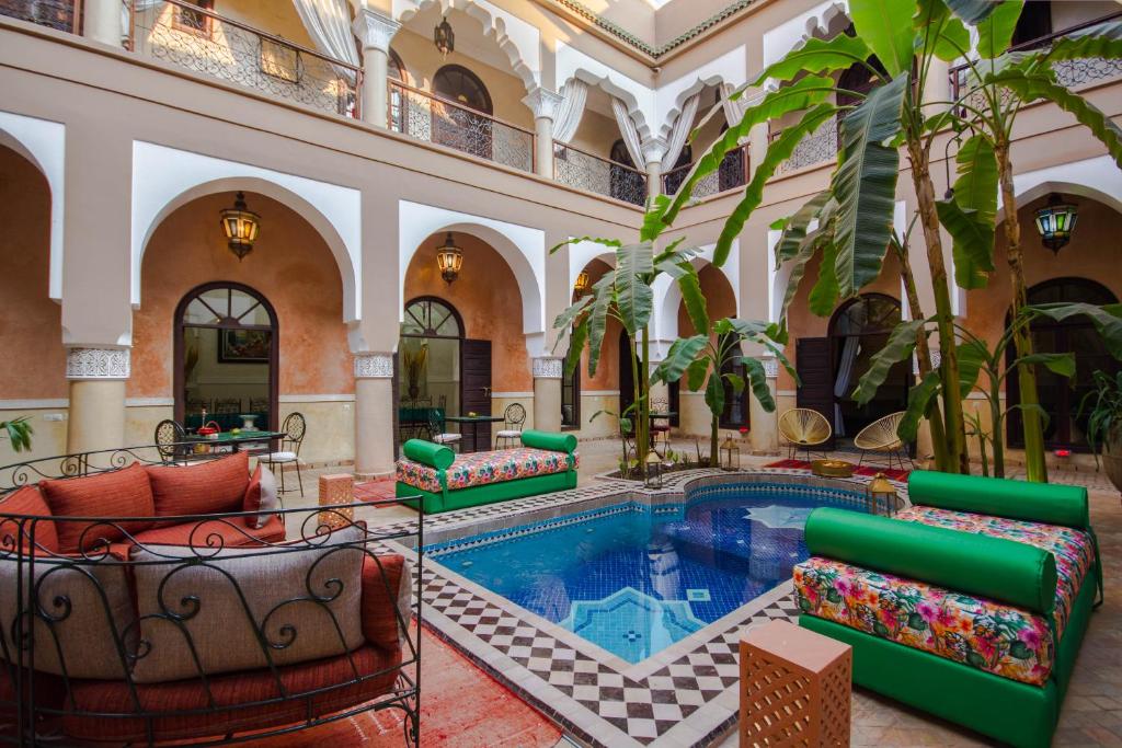 a pool in a building with chairs and a swimming pool at Riad Nabila in Marrakesh