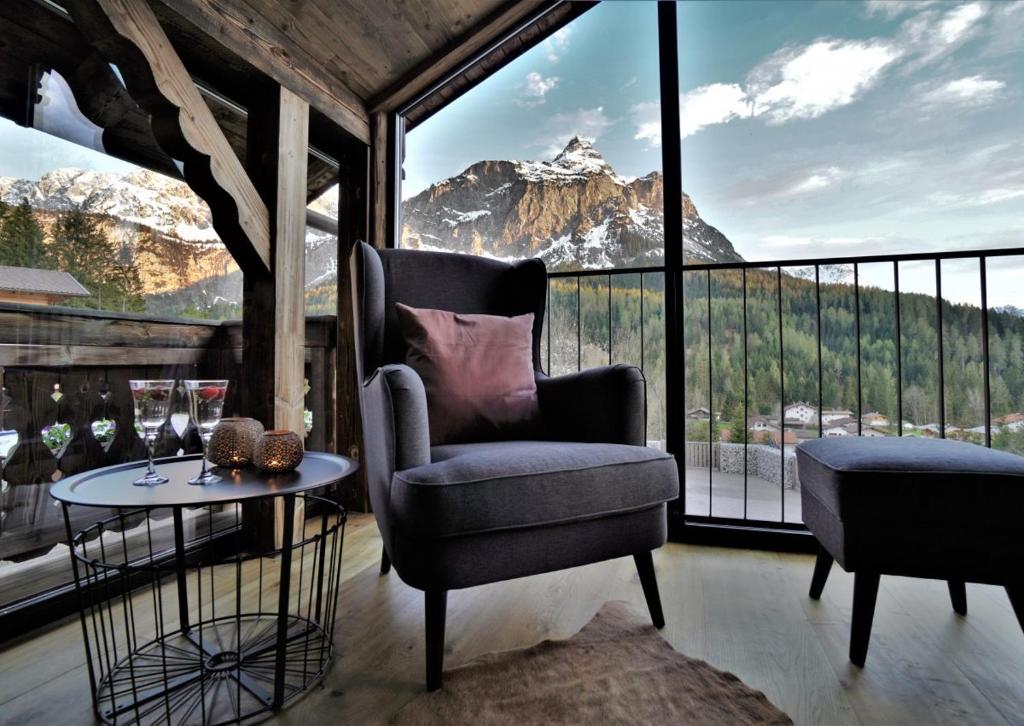 a room with a chair and a table and a mountain view at Das Hof Chalet in Ehrwald