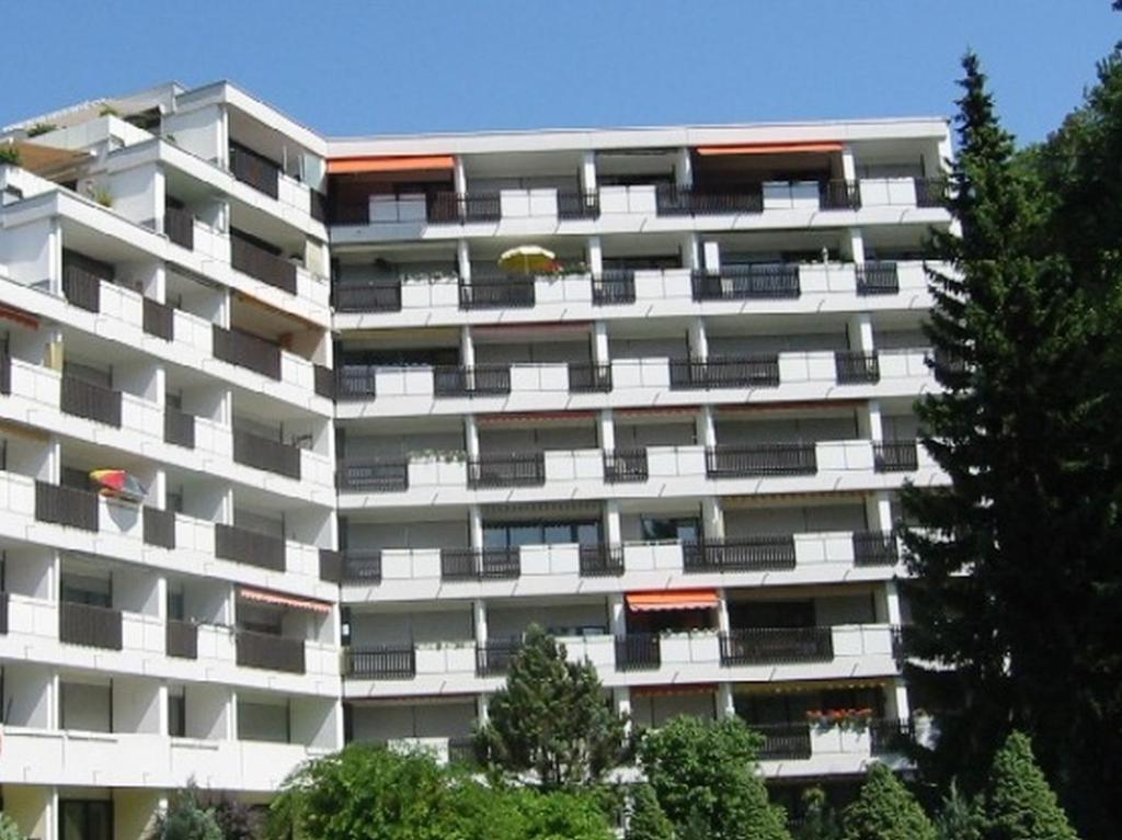 バートライヘンハルにあるCity Appartementの目の前に木々が生い茂る白いアパートメント