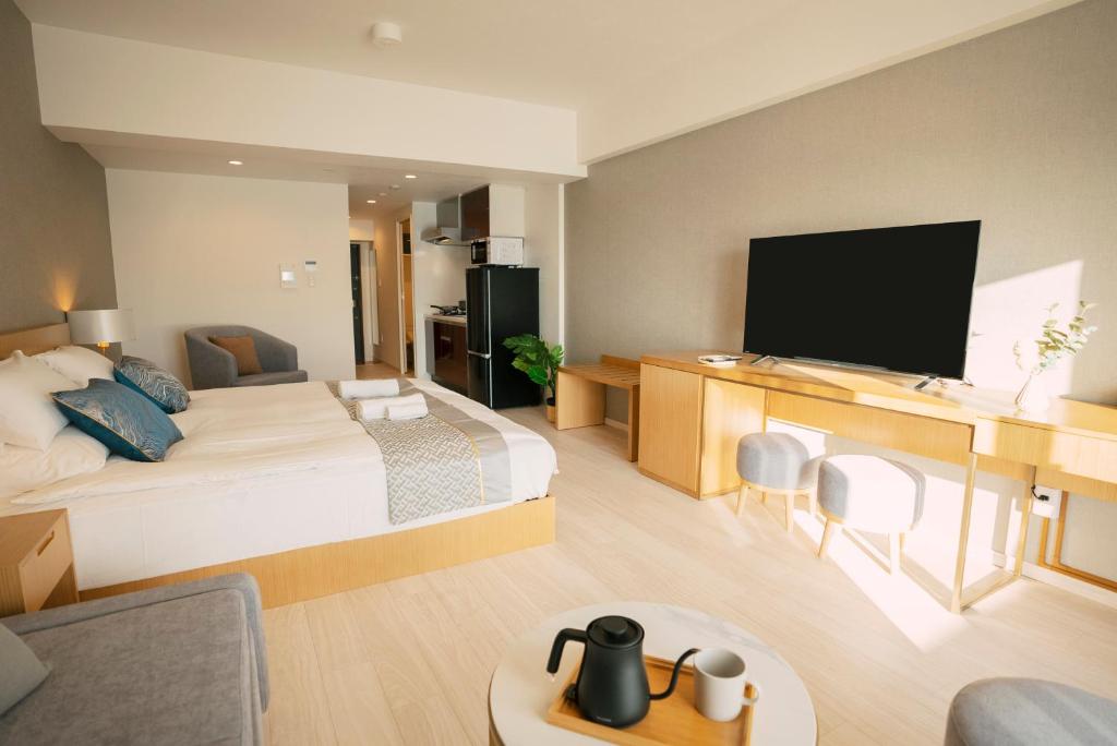 um quarto de hotel com uma cama e uma televisão de ecrã plano em 谷町君 HOTEL 恵美須町72 em Osaka