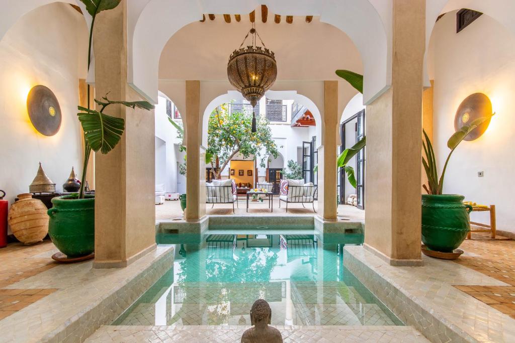 an indoor pool in a house with potted plants at Dar Charkia in Marrakesh