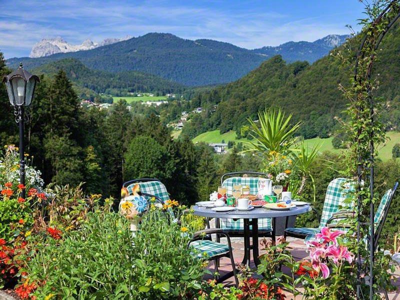 een tafel en stoelen in een tuin met bergen bij Ferienhaus Angerer in Berchtesgaden