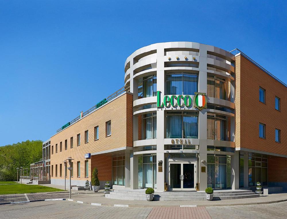 a large brick building with a sign on it at Lecco Hotel in Mytishchi