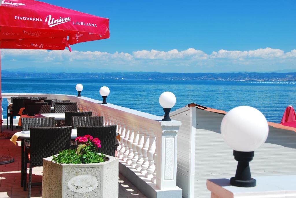 a balcony with tables and chairs and the water at Hotel Fiesa in Piran