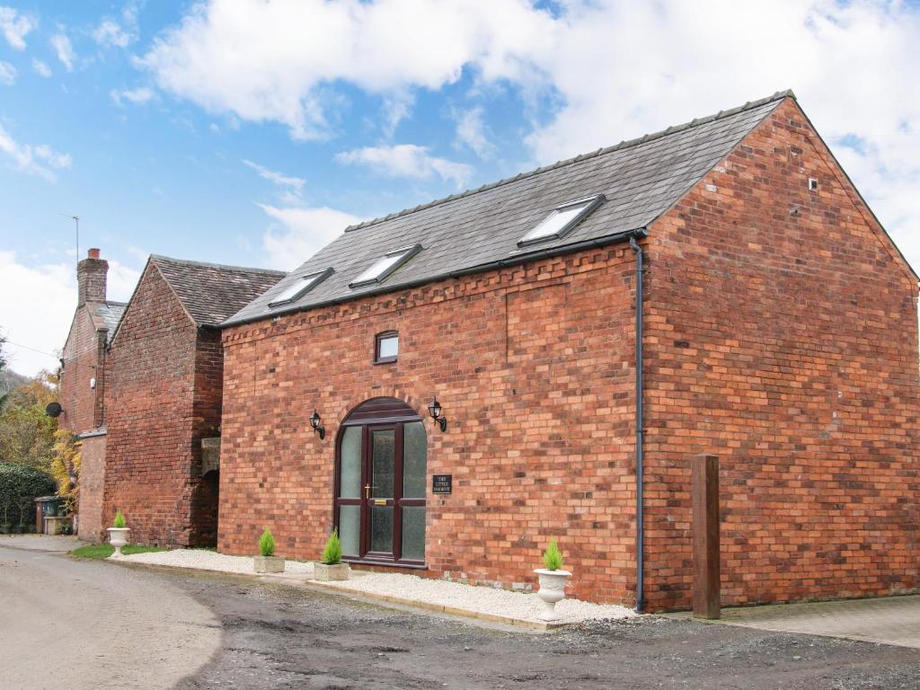 a red brick building with a black roof at The Little Beehive in Worcester