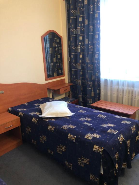 a bedroom with a bed with a blue blanket at HOTEL MUNTENIA in Campina