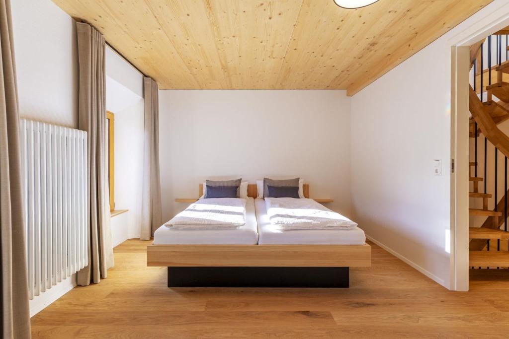 ein Schlafzimmer mit einem Bett und einer Holzdecke in der Unterkunft Apartments Bären in Elzach