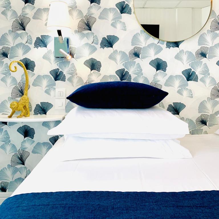 a bedroom with a bed with a blue and white wallpaper at Hôtel Gaspard in Le Touquet-Paris-Plage