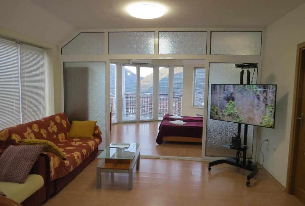 un soggiorno con divano e TV di Panoramic Apartment 301 in Eagle Rock Complex a Beli Iskar