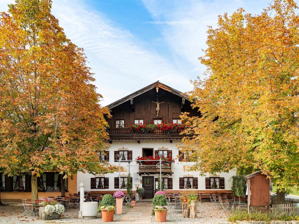 um edifício com uma varanda com flores vermelhas em Landhotel Kistlerwirt em Bad Feilnbach