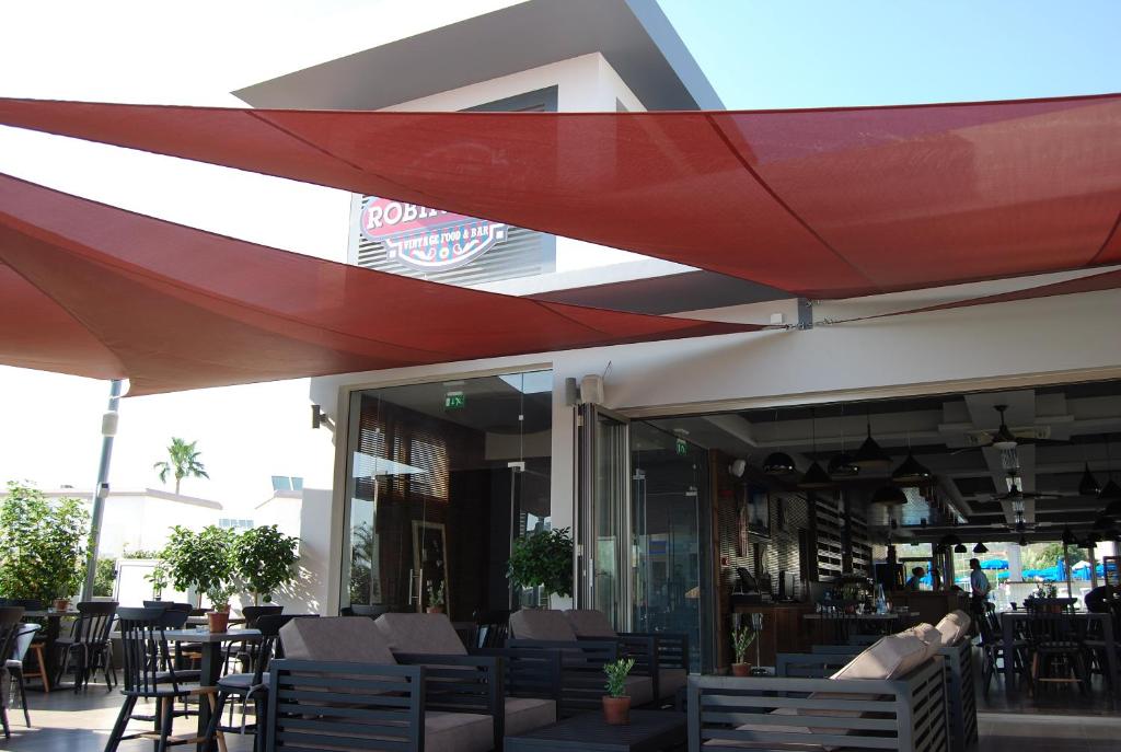 a restaurant with tables and chairs under a red umbrella at Euronapa Hotel Apartments in Ayia Napa