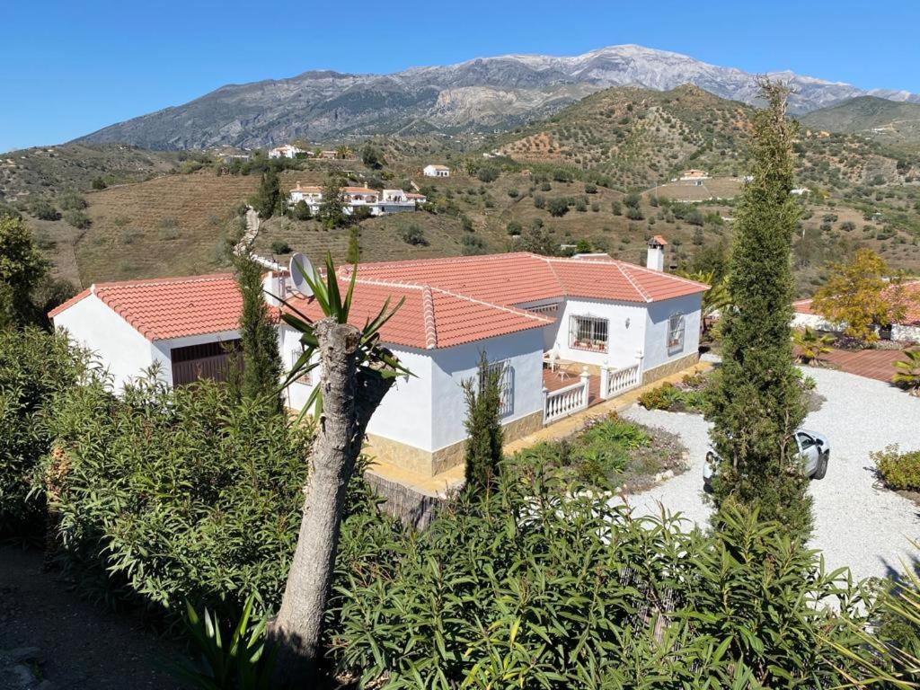 una casa bianca con un tetto rosso su una collina di Casa de Las Rosas a Málaga