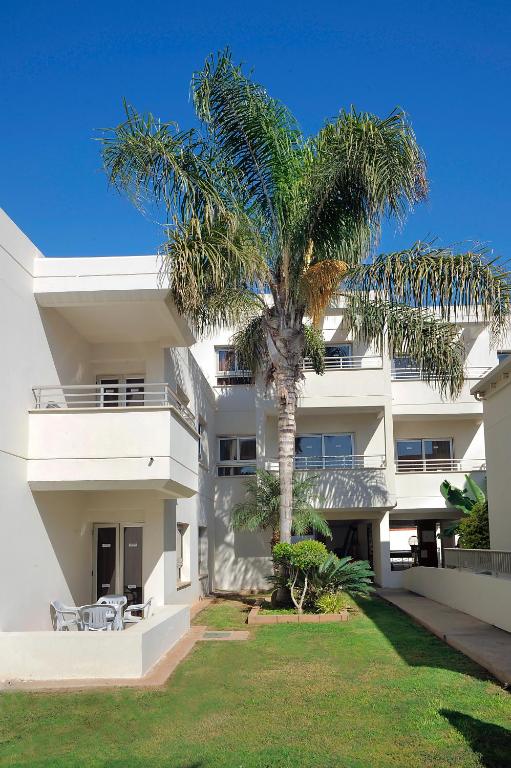 a palm tree in front of a white building at Euronapa Hotel Apartments in Ayia Napa