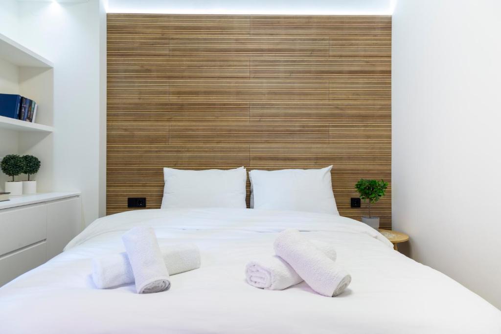 a bedroom with a white bed with two towels on it at K2 SUITE in Thessaloniki