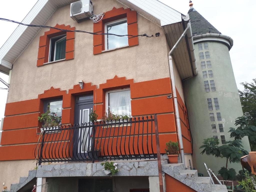 un edificio con adornos naranjas y balcón en Sárkány Lak en Diósd