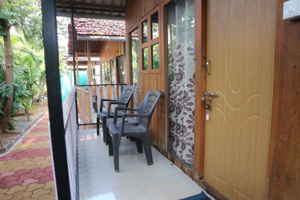 a row of chairs sitting on a porch at Palolem Cottages in Palolem