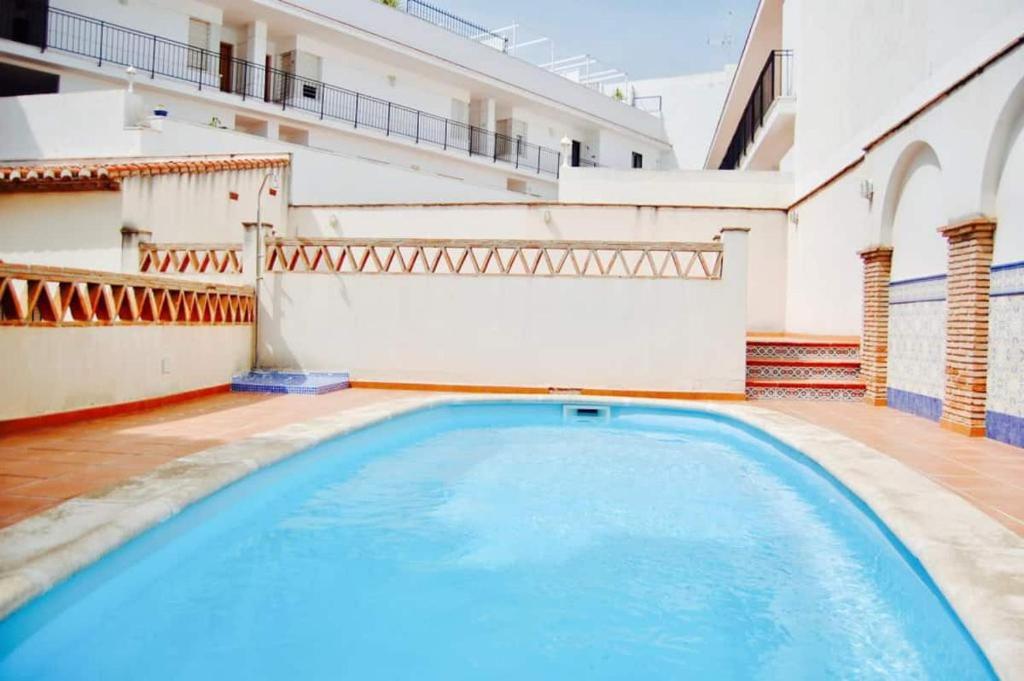 a swimming pool in the middle of a house at Fantastic 1 bedroom apartment in the centre of Nerja in Nerja