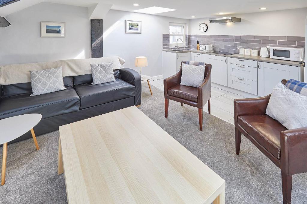 ein Wohnzimmer mit einem Sofa und 2 Stühlen in der Unterkunft Host & Stay - The Lealholm at Brunswick Holiday Apartments in Whitby