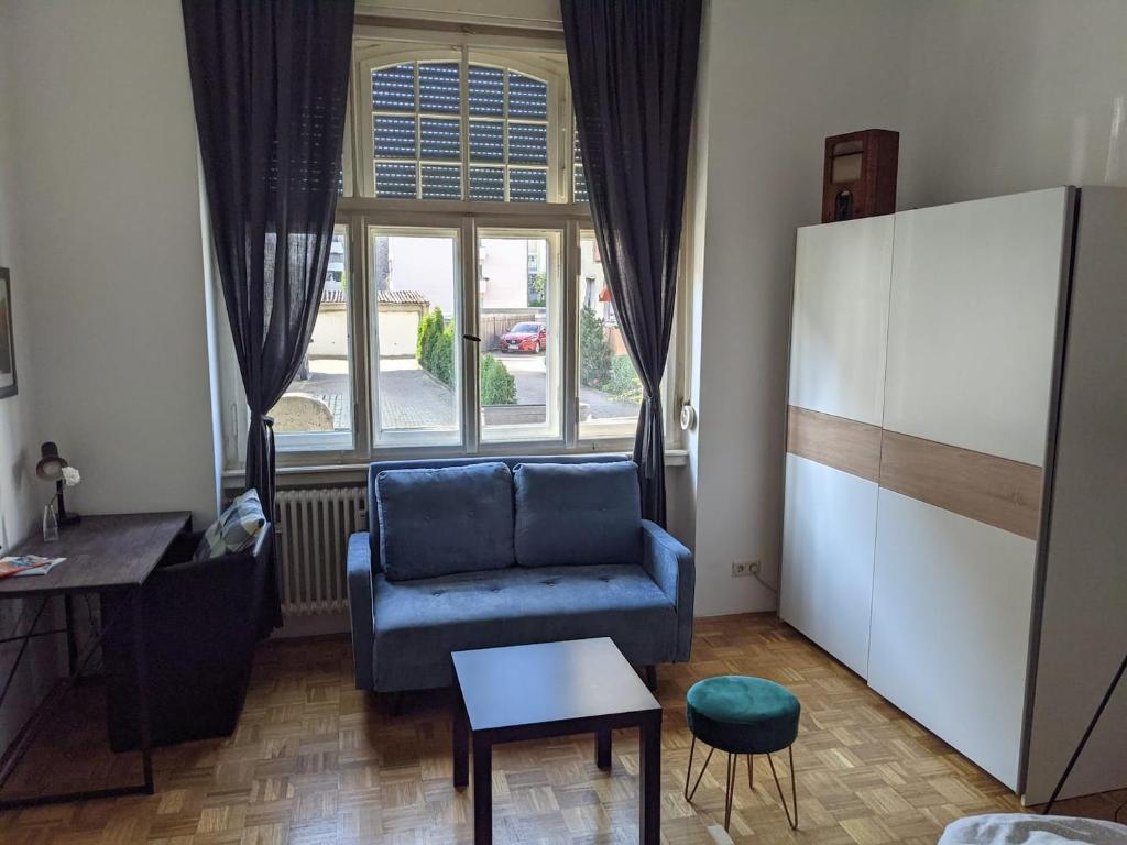 - un salon avec un canapé bleu et une fenêtre dans l'établissement Wohnen am Main - gemütlicher Altbau, zentral, à Wurtzbourg