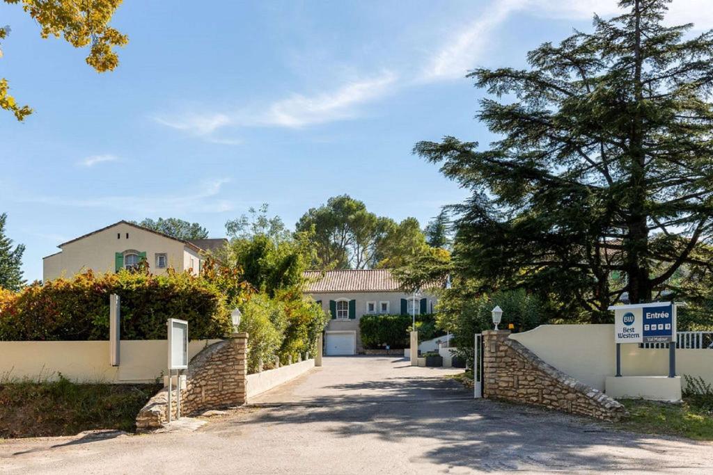 ein Haus mit einem Tor und einer Einfahrt in der Unterkunft Best Western Le Val Majour in Fontvieille