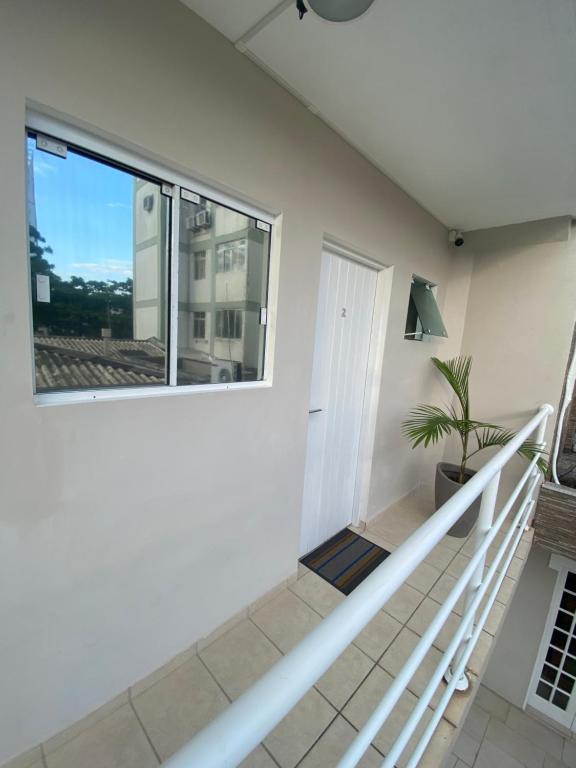 a staircase in a house with a window at AP FRENTE À PRAÇA BEM LOCALIZADO 02 in São José