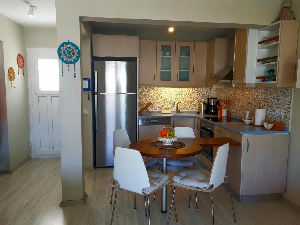 eine Küche mit einem Tisch und Stühlen sowie einem Kühlschrank in der Unterkunft Apartment Begonville in Bodrum City