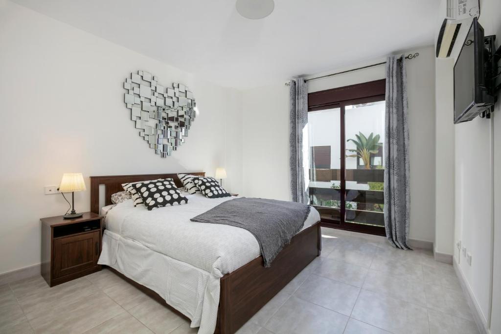 een slaapkamer met een bed en een groot raam bij FIVE STAR 3 bedroom Apt in ideal location - RDR237 in Marbella