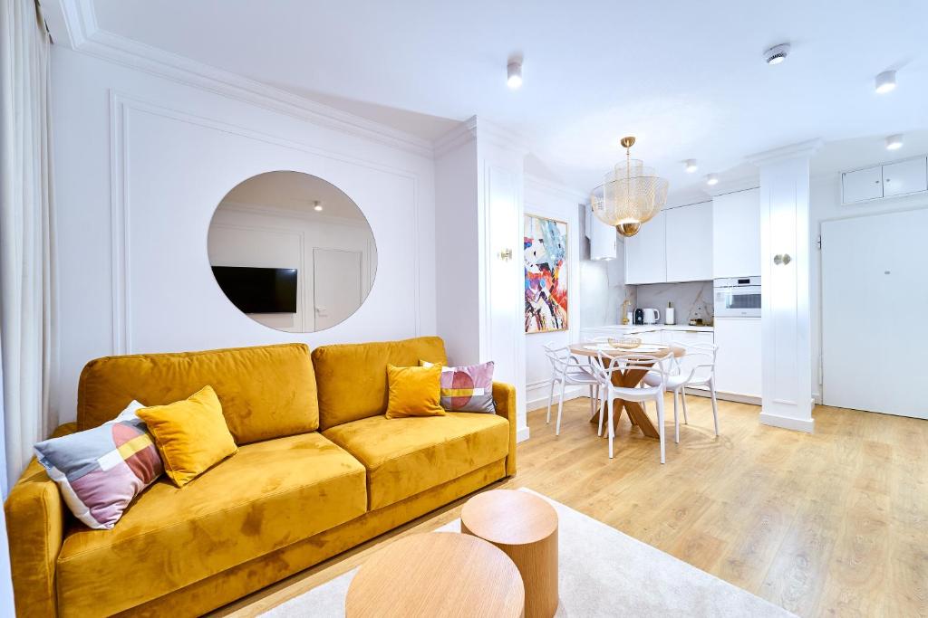 een woonkamer met een gele bank en een tafel bij LAGUNA Apartament Polanica Residence 20 in Polanica-Zdrój