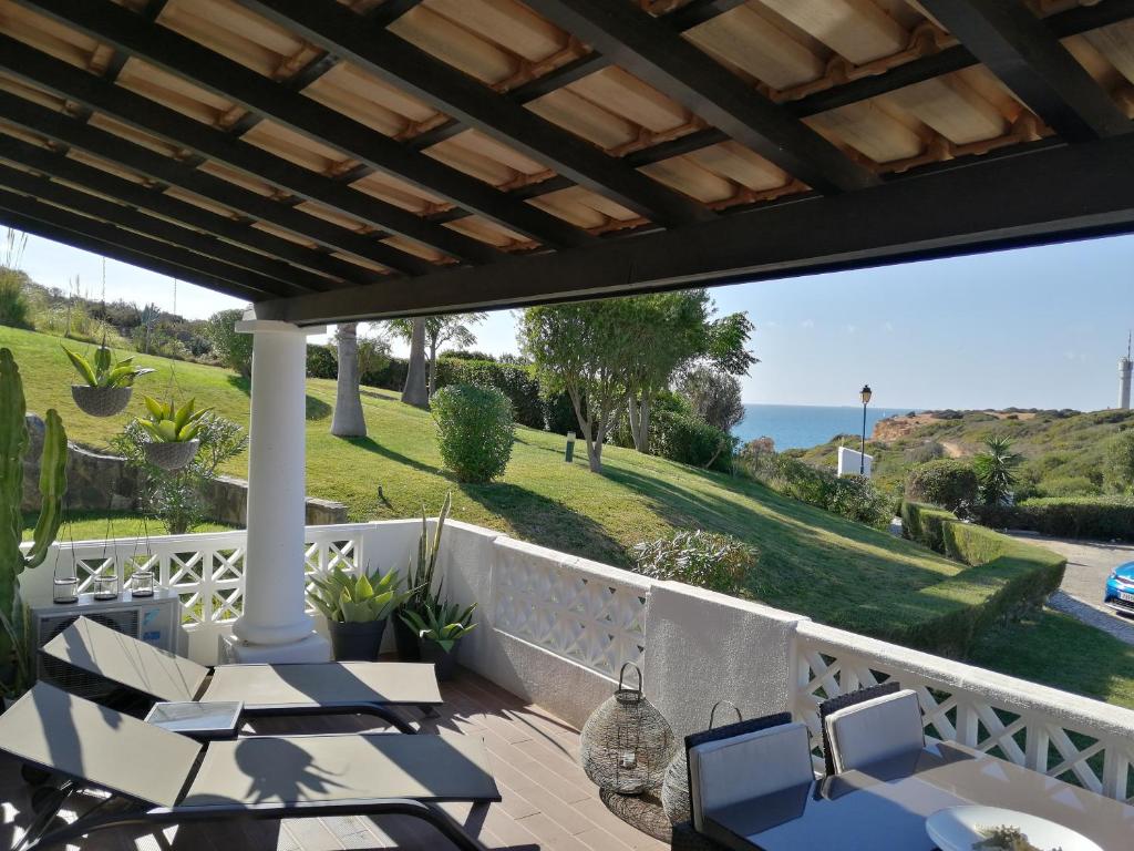 eine Terrasse mit Tischen und Stühlen und Meerblick in der Unterkunft OCEAN TERRACES by VILA GAIVOTA D in Ferragudo