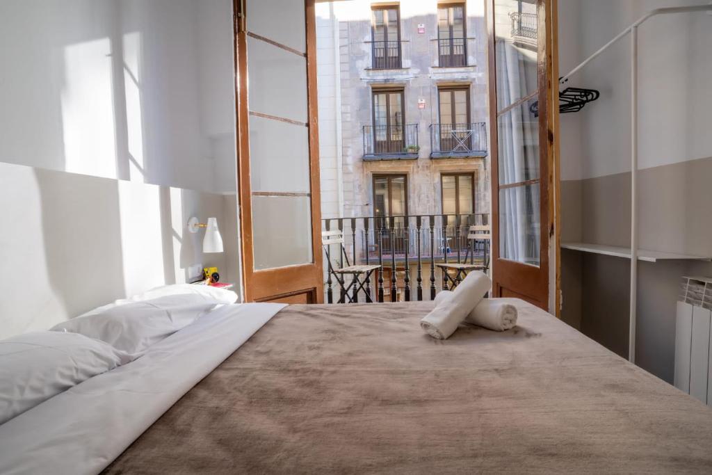 - une chambre avec un grand lit et une grande fenêtre dans l'établissement Hostal Hera, à Barcelone