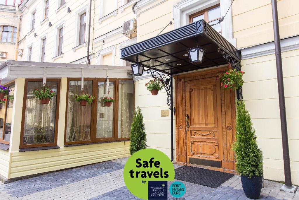 a building with a gate travels sign in front of a door at Hotel Moyka 5 in Saint Petersburg