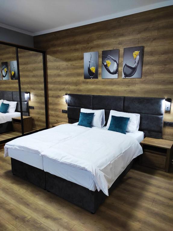 a bedroom with a large white bed with blue pillows at Apart Club Tolstogo in Chernivtsi