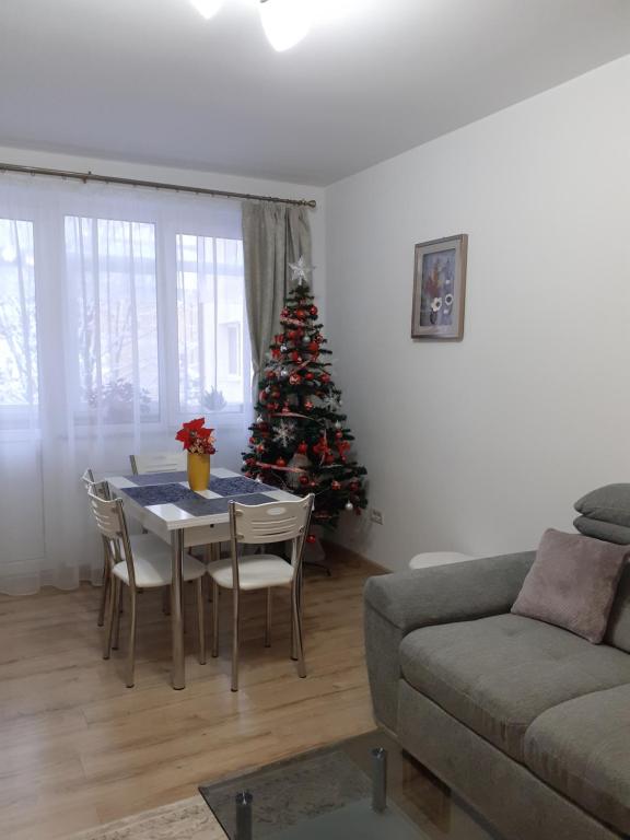 uma sala de estar com uma mesa e uma árvore de Natal em Apartament Ultra Central Marly Gura Humorului em Gura Humorului