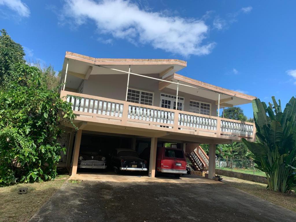 a house with a balcony and a car garage at confort apto con balcones in Vega Alta