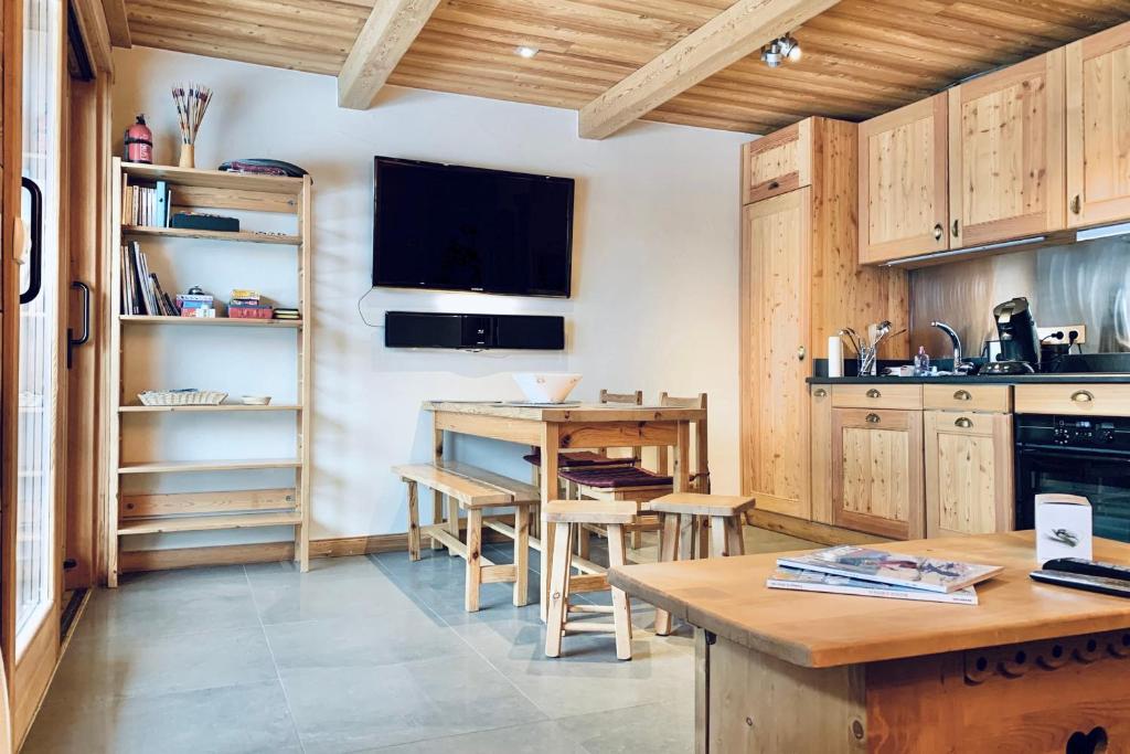 a kitchen with wooden cabinets and a table and a television at The mountain charmer #AH11 in LʼHuez