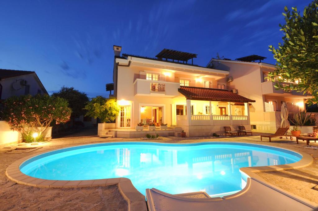 Villa con piscina frente a una casa en Apartments Villa Marnii, en Kožino