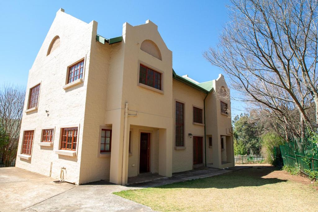 a large white building with a tree in front of it at Gecko Castle in Dullstroom