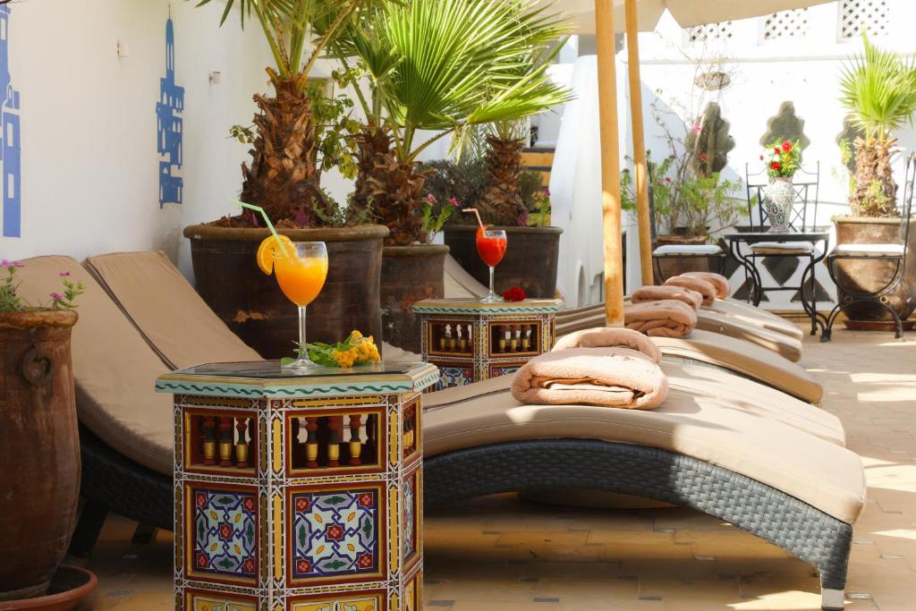 Habitación con 1 cama, 2 mesas y plantas en Riad Palais Des Princesses & Spa, en Marrakech