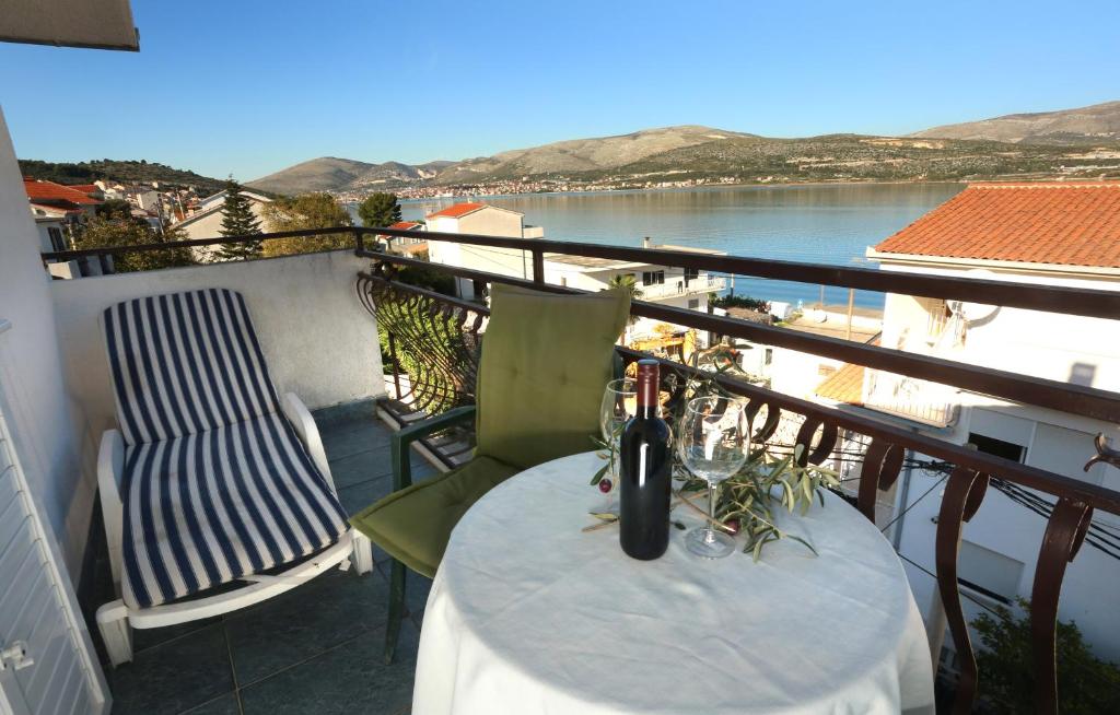 balcón con mesa, sillas y vistas al agua en Apartments Sikirica en Trogir