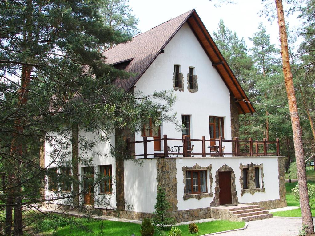 una casa blanca con techo de gambrel en Pershyi Kordon Tourist Complex, en Medvedevka